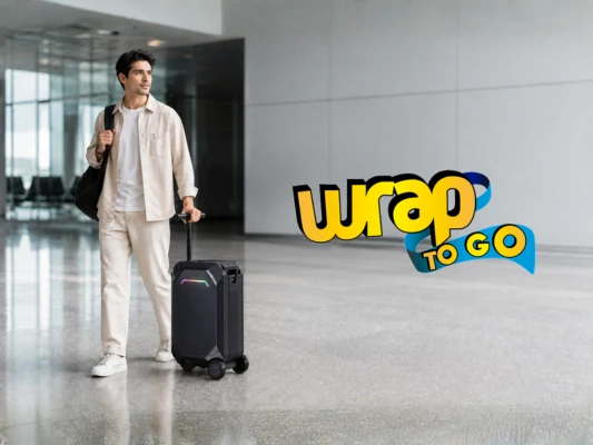 Viajero latino con rolling suitcase inteligente de mano en terminal moderna