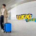 Viajera con maleta con ruedas azul en una terminal moderna