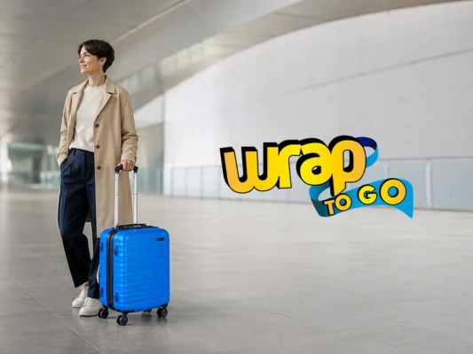 Viajera con maleta con ruedas azul en una terminal moderna