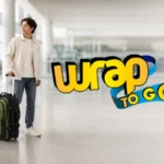 Viajero con mochila desmontable y maleta con ruedas en terminal de aeropuerto