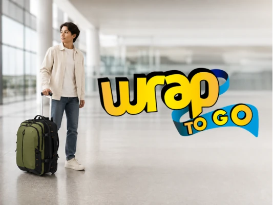 Viajero con mochila desmontable y maleta con ruedas en terminal de aeropuerto